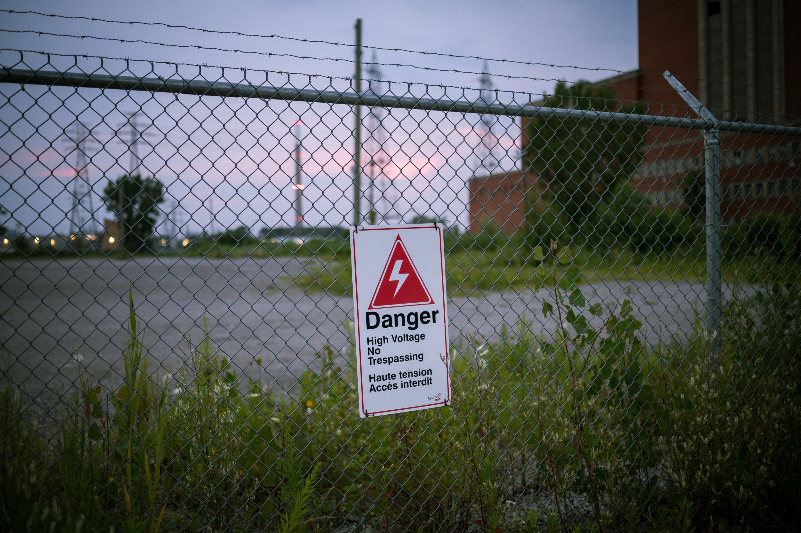 Warning sign displayed on a pet containment fence line