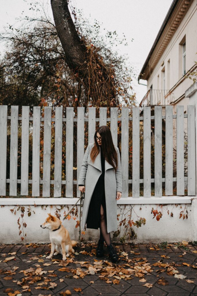Woman standing beside a white privacy fence