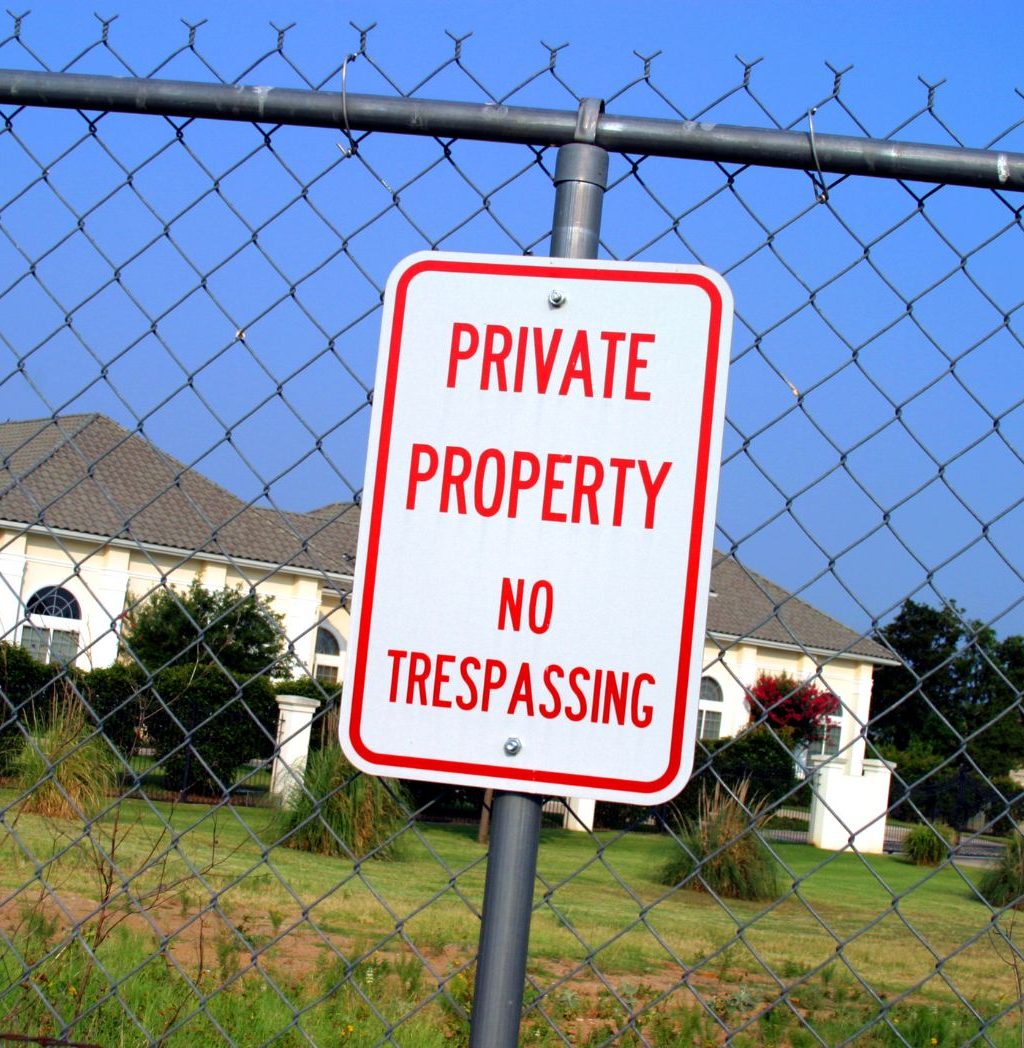 Fence sign marking a secured property boundary